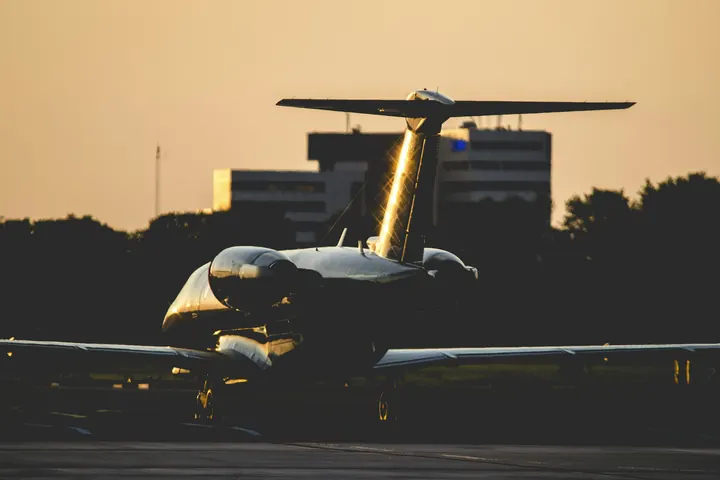 A business jet on the ramp at night under warm floodlights
