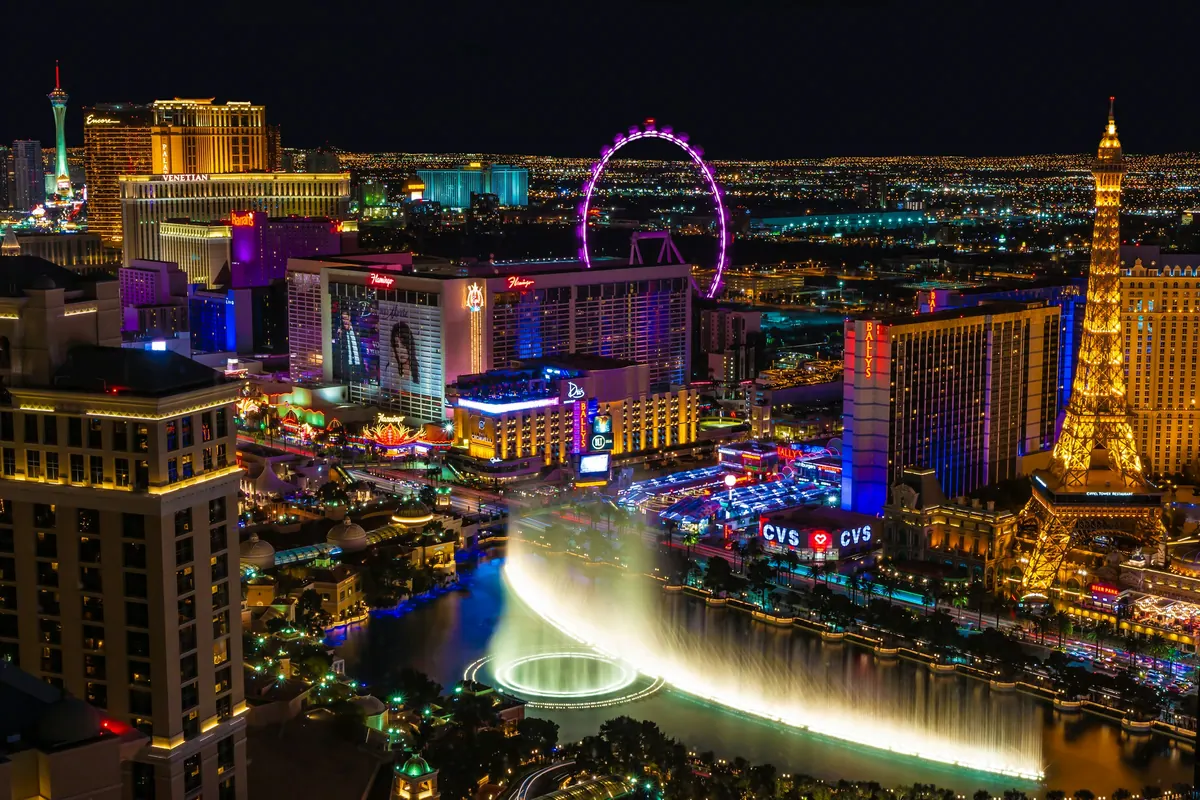 The Las Vegas Strip at night from above, with the Bellagio fountains and the lights of the resorts