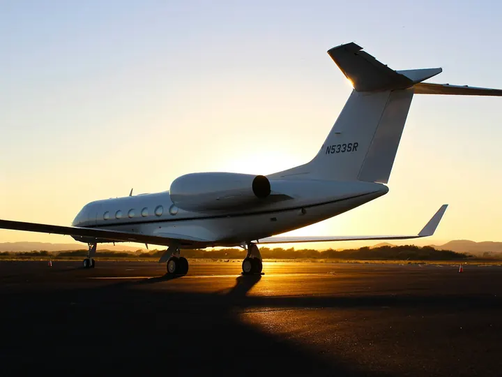 A large-cabin jet on the ramp at sunset