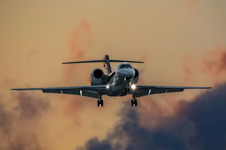 A business jet descending through clouds on approach