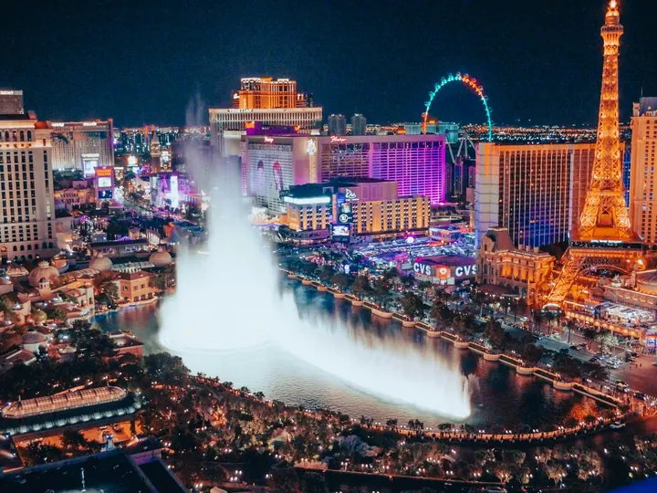 The Bellagio fountains lit up at night on the Strip