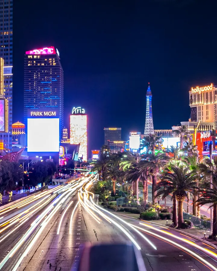 Light trails of traffic along the Strip beside glowing casino signs